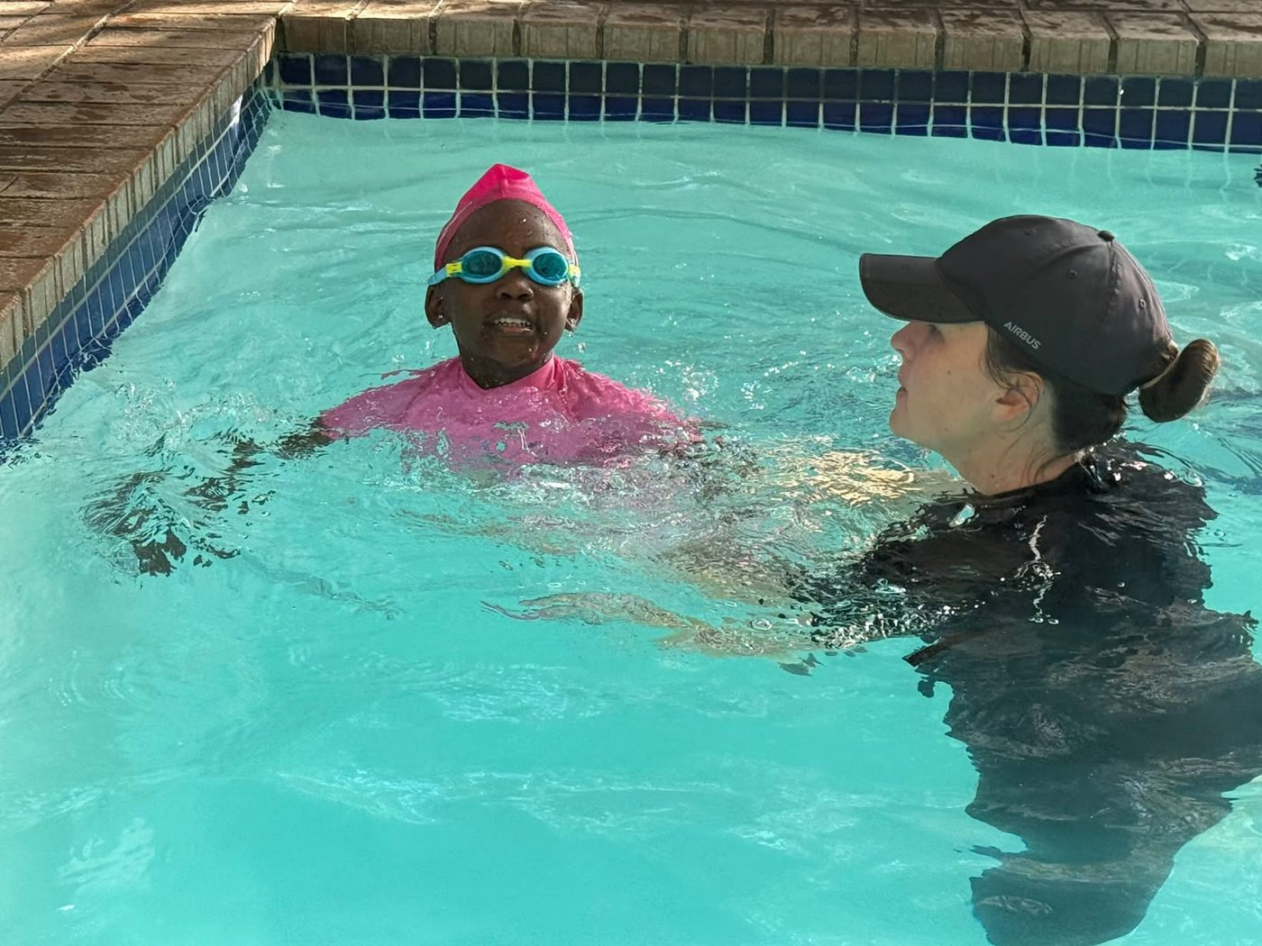 Instructor with a child wearing goggles during a swimming lesson
