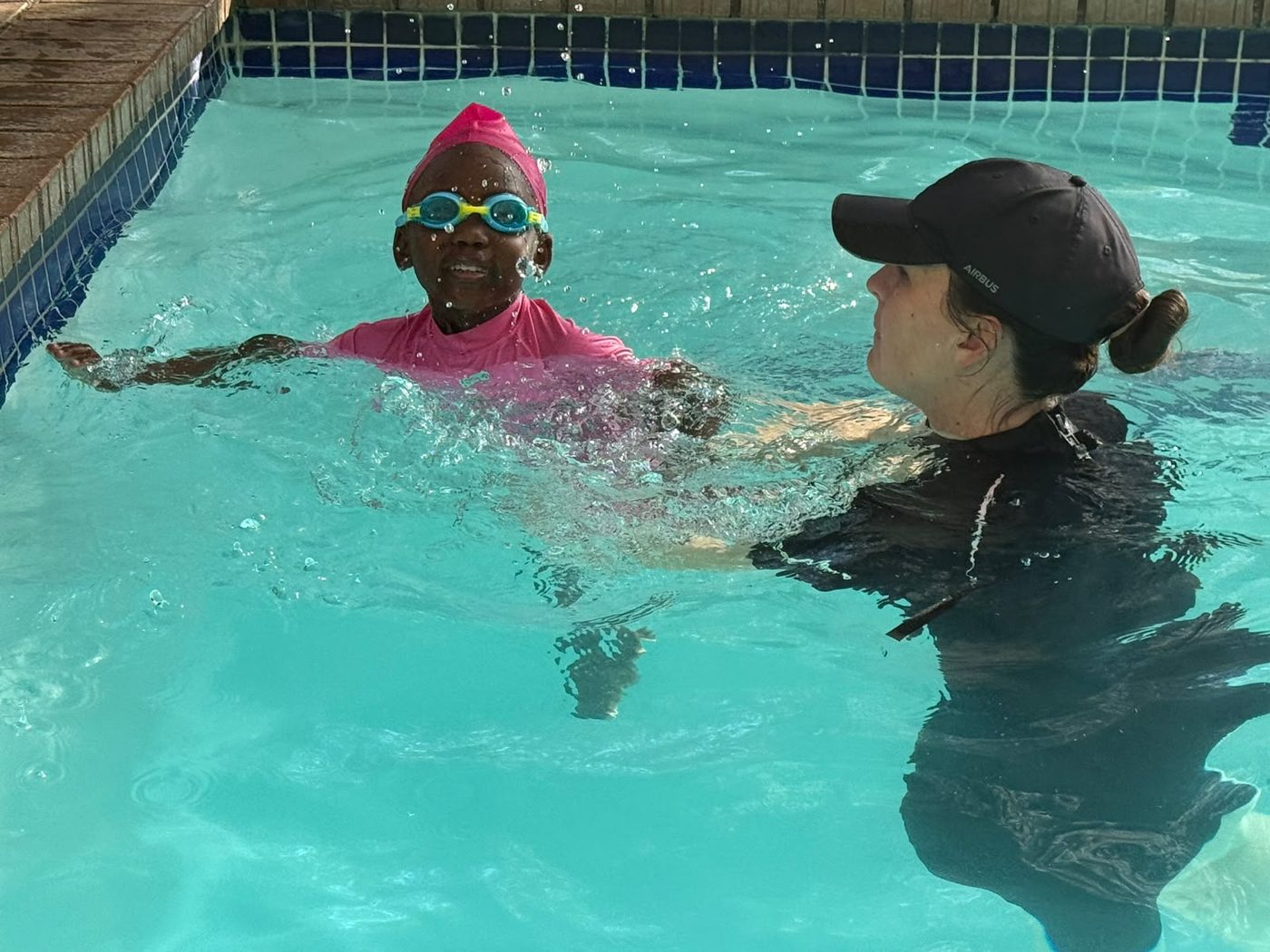 An instructor guiding a young swimmer through a lesson